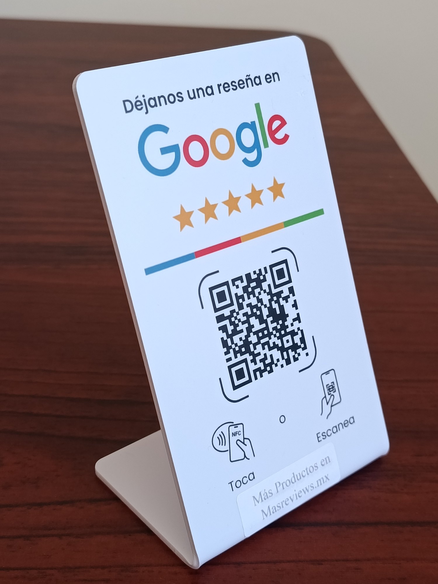 La pieza parada sobre una mesa de madera: la cara blanca invita a dejar una reseña en Google, con cinco estrellas, el código para escanear y las dos formas de usarla.
